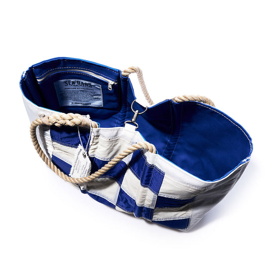Sea Bags’ November Signal Flag Large Tote features blue and white recycled sail cloth, sturdy rope handles, an open design revealing a blue interior, a zippered white inside pocket, and a fabric brand label. by Sea Bags