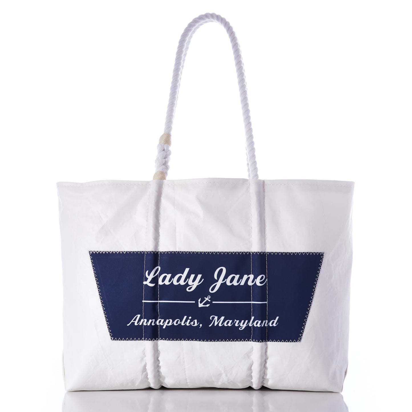 Sea Bags Custom Boat Name Tote in white, designed with rope handles and finished with a navy blue patch featuring an anchor and the text “Lady Jane Annapolis, Maryland” at the center. by Sea Bags