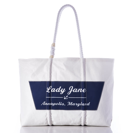 Sea Bags Custom Boat Name Tote in white, designed with rope handles and finished with a navy blue patch featuring an anchor and the text “Lady Jane Annapolis, Maryland” at the center. by Sea Bags