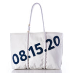 Introducing the Custom Date Tote from Sea Bags—a white tote bag with sturdy rope handles, showcasing the date 08.15.20 in bold blue numbers across the front. This personalized tote also comes with a custom message patch, making it a unique and meaningful keepsake for any special occasion. by Sea Bags