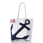 Sea Bags Custom Monogram Anchor Tote—crafted from recycled sailcloth, this stylish white tote features a blue anchor graphic, bold red monogrammed initials, and sturdy white rope handles. Displayed on a plain white background, it’s the perfect personalized gift or custom anchor tote for any occasion. by Sea Bags