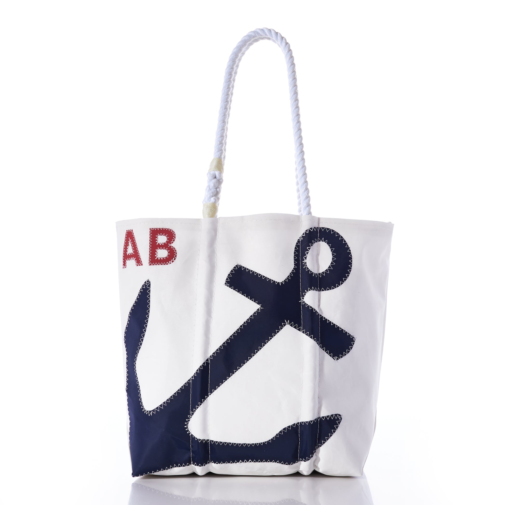 Sea Bags Custom Monogram Anchor Tote—crafted from recycled sailcloth, this stylish white tote features a blue anchor graphic, bold red monogrammed initials, and sturdy white rope handles. Displayed on a plain white background, it’s the perfect personalized gift or custom anchor tote for any occasion. by Sea Bags