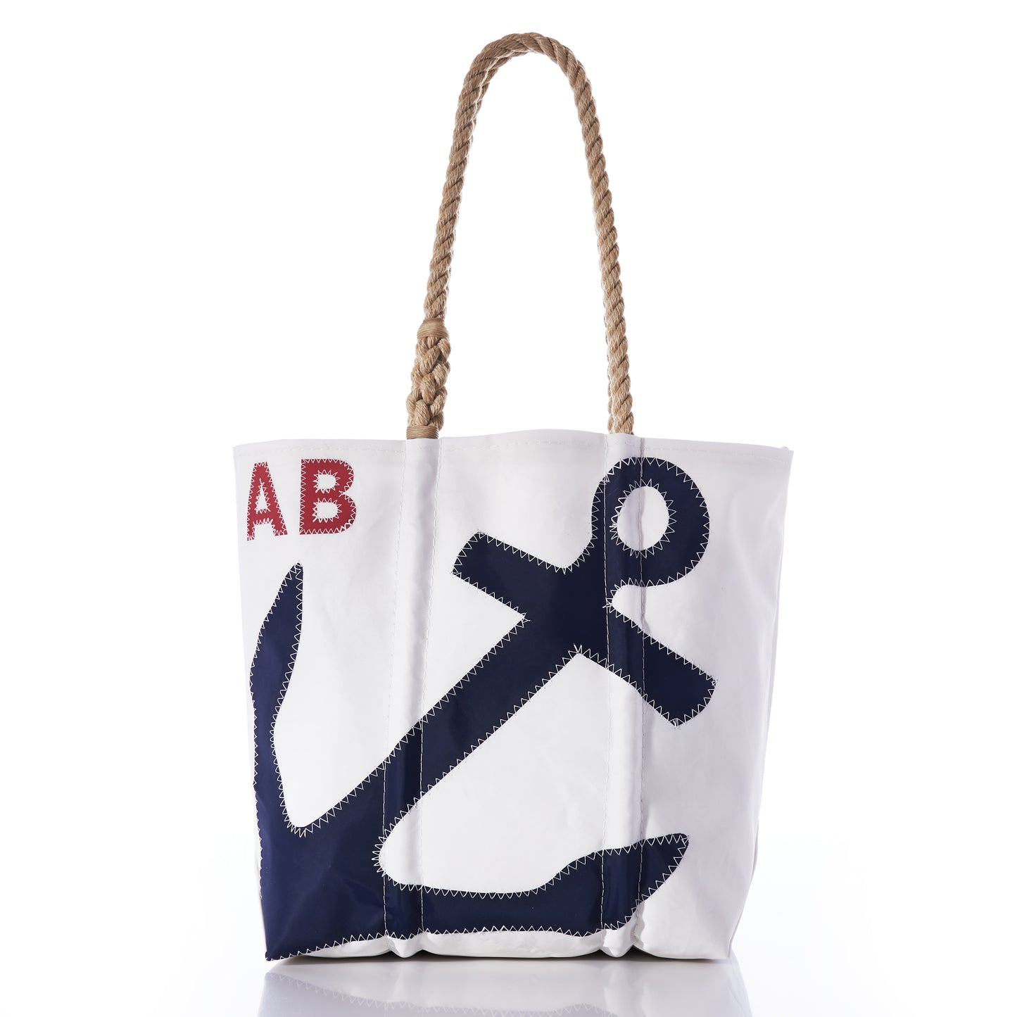 Introducing the Sea Bags Custom Monogram Anchor Tote—a white tote bag made from recycled sailcloth, designed with sturdy rope handles. It showcases a bold navy blue anchor on the front and personalized red initials AB in the upper left corner. This eco-friendly anchor tote provides a unique and thoughtful gift for any occasion. by Sea Bags