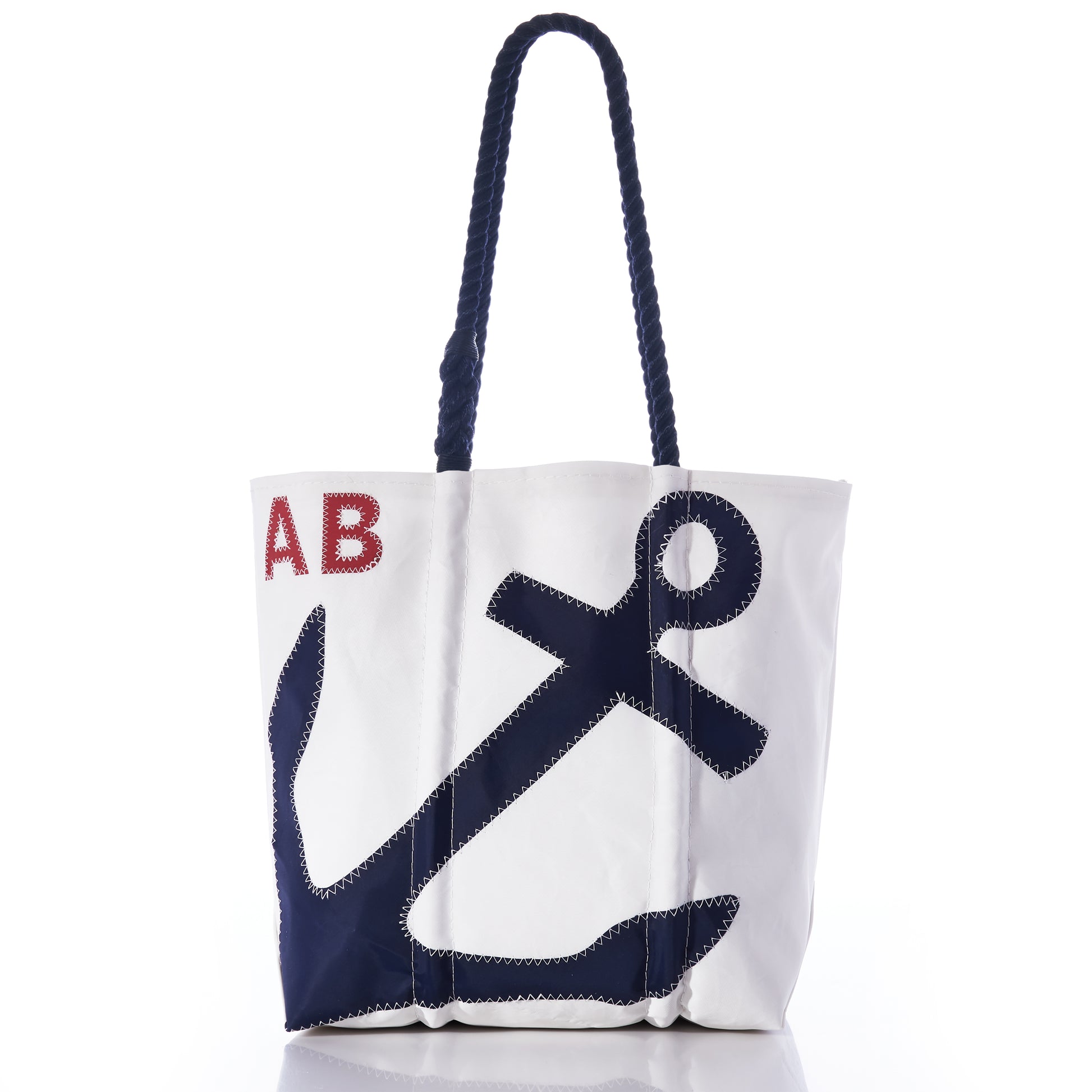 Sea Bags Custom Monogram Anchor Tote: A white tote bag with navy blue rope handles, featuring a large stitched navy anchor and red-stitched initials “AB” in the upper left corner—expertly crafted from recycled sailcloth for a unique personalized gift. by Sea Bags