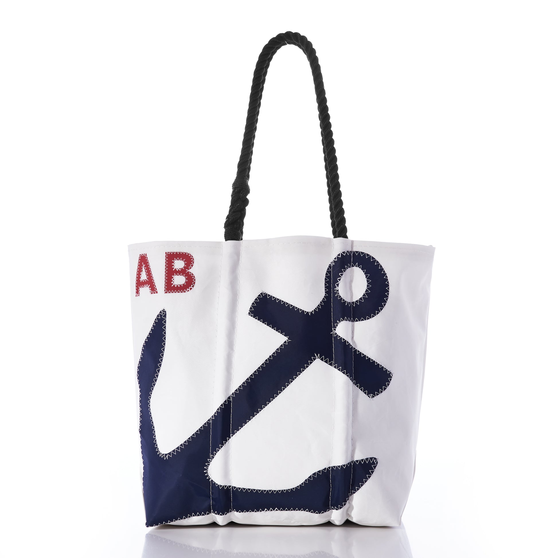 Introducing the Sea Bags Custom Monogram Anchor Tote—a stylish white tote with black rope handles, highlighted by a bold dark blue anchor and custom red-stitched initials in the upper left corner. Crafted from recycled sailcloth, this personalized anchor tote makes a thoughtful and unique gift. by Sea Bags