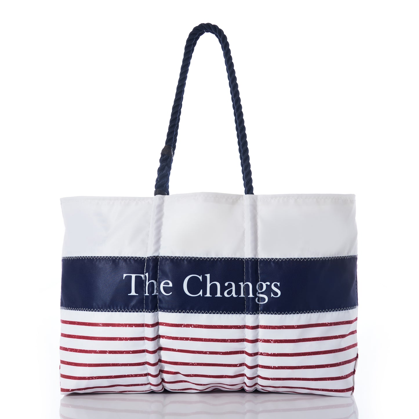 Introducing the Sea Bags Custom Mariner Stripe Tote—a white recycled sail cloth bag featuring a bold navy stripe personalized with The Changs, accented by striking red stripes along the bottom and finished with sturdy dark rope handles. This nautical-inspired tote combines eco-conscious craftsmanship with standout style. by Sea Bags