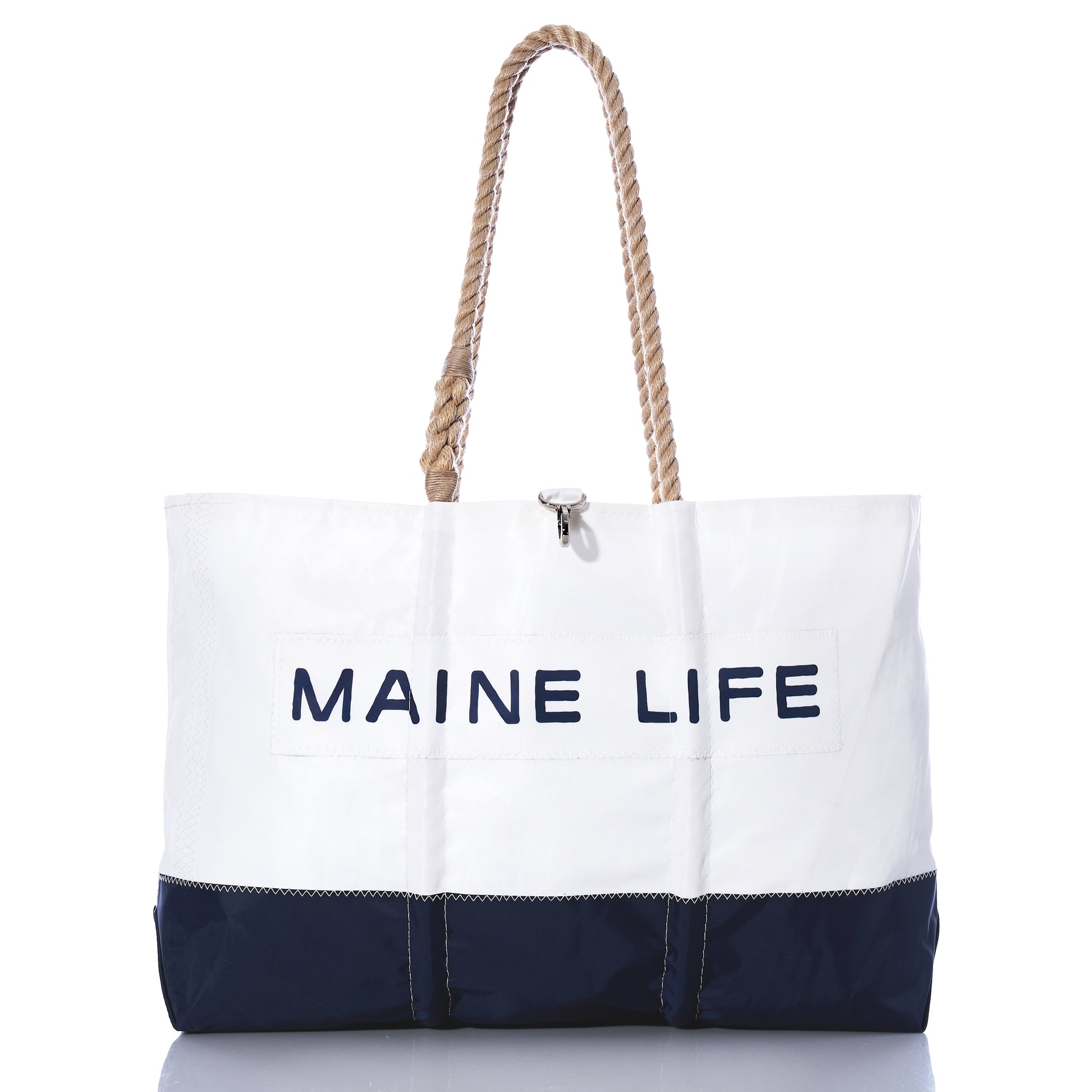 The Sea Bags Maine Life Large Tote is a spacious white and navy bag featuring sturdy rope handles and MAINE LIFE printed on the front, photographed against a white background. Inspired by Erin Ovalle’s signature Maine Life collection, this tote is perfect for everyday adventures. by Sea Bags