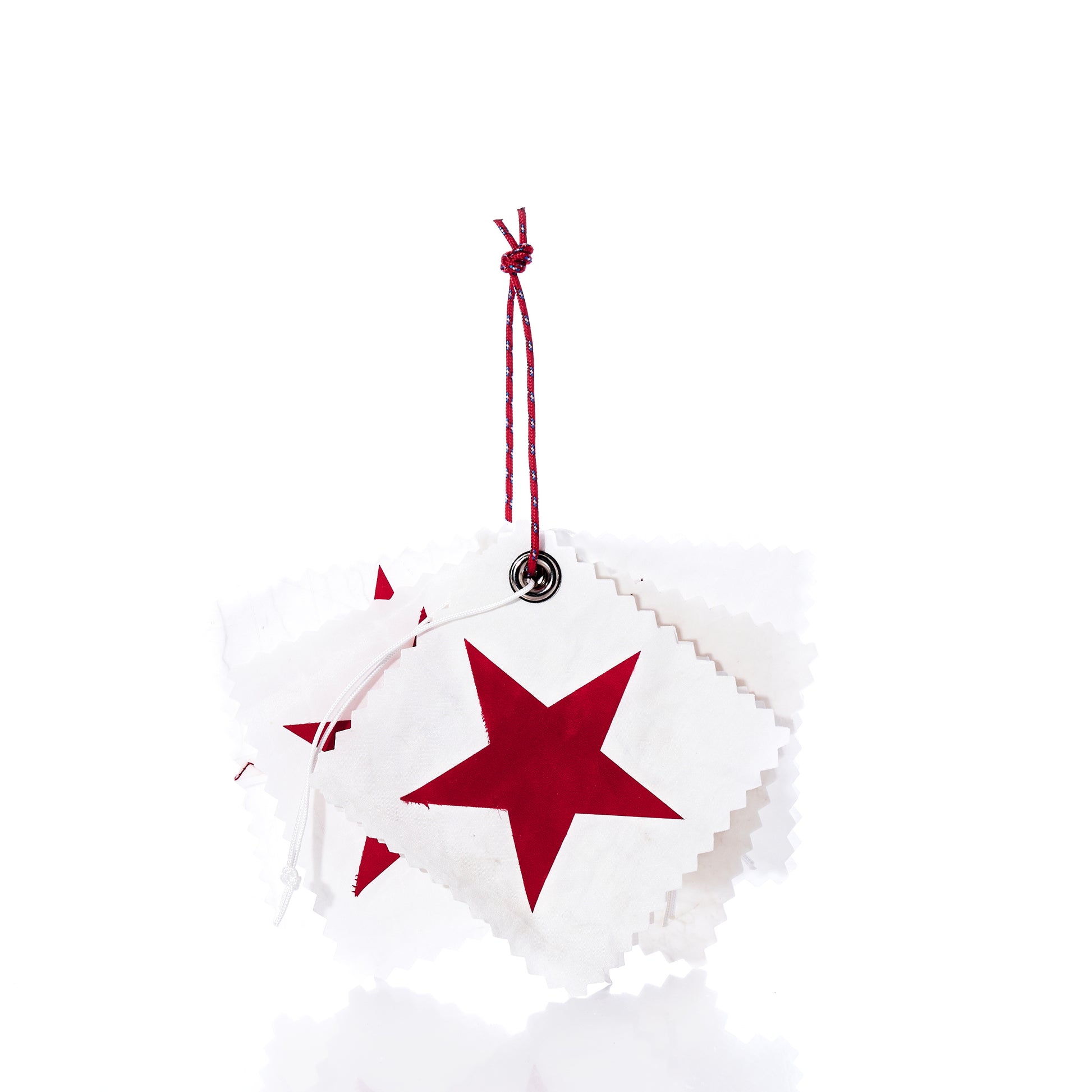 A set of five white square Sea Bags Sail Cloth Gift Tags, each adorned with a red star and crafted from sustainable recycled sail material, are stacked and tied together with a red and white string against a white background. by Sea Bags