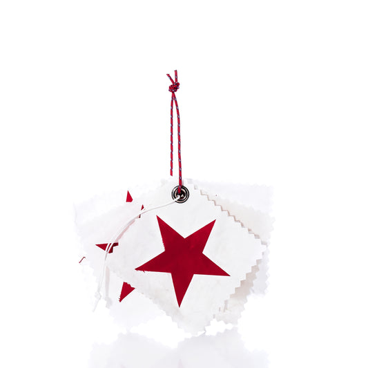 A set of five white square Sea Bags Sail Cloth Gift Tags, each adorned with a red star and crafted from sustainable recycled sail material, are stacked and tied together with a red and white string against a white background. by Sea Bags