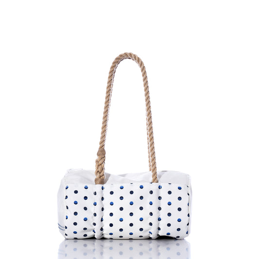 The Flip Side Summer Dots Baguette Bag by Sea Bags features a white design adorned with navy blue polka dots and two thick, twisted rope handles. Photographed on a white background with a subtle reflection below, this chic summer handbag blends charm and practicality—ideal for sunny day outings. by Sea Bags