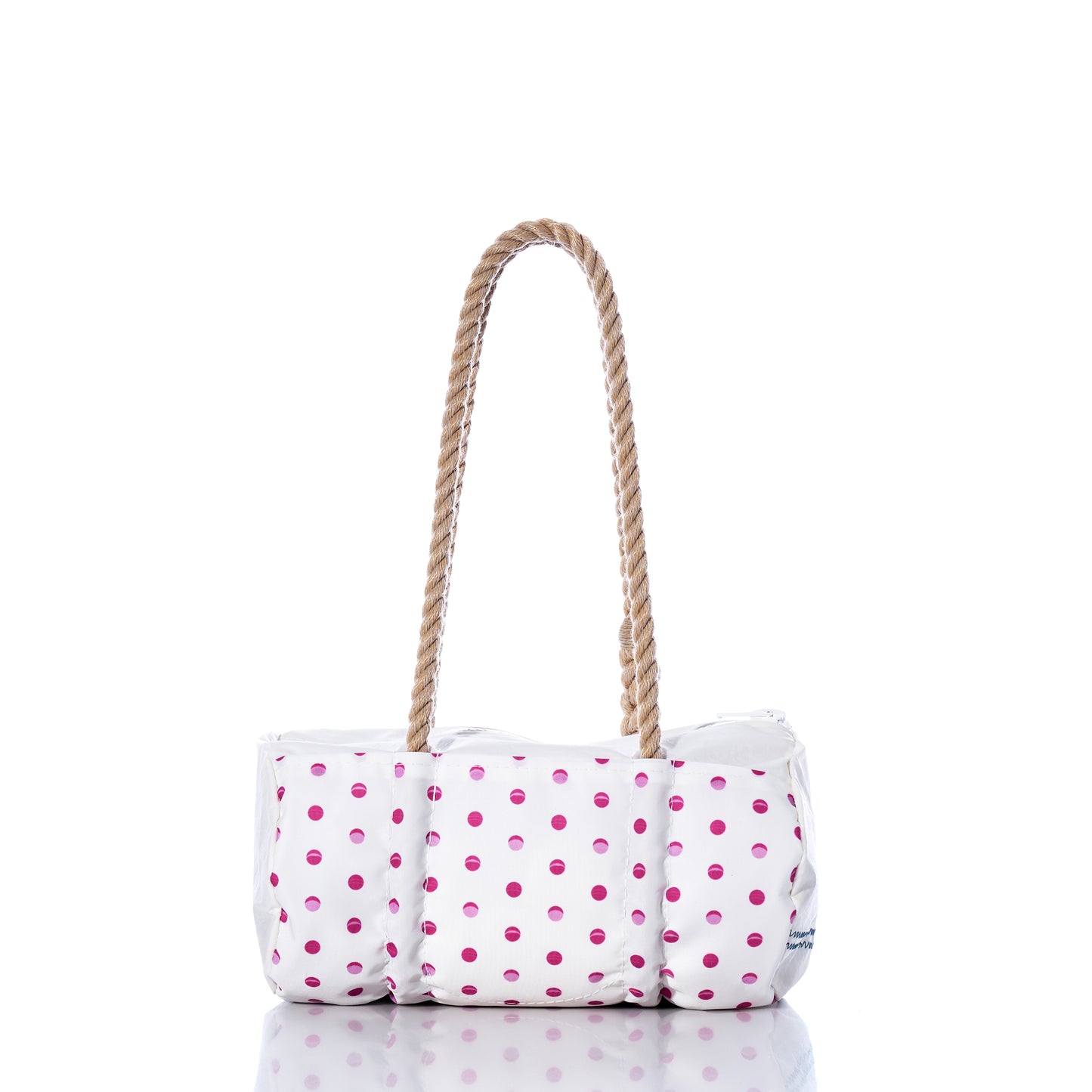 The Flip Side Summer Dots Baguette Bag by Sea Bags features a white tote design adorned with pink polka dots, a cushioned body, and two brown rope handles. Displayed on a reflective surface against a white background, this charming summer handbag blends playful style with everyday practicality. by Sea Bags