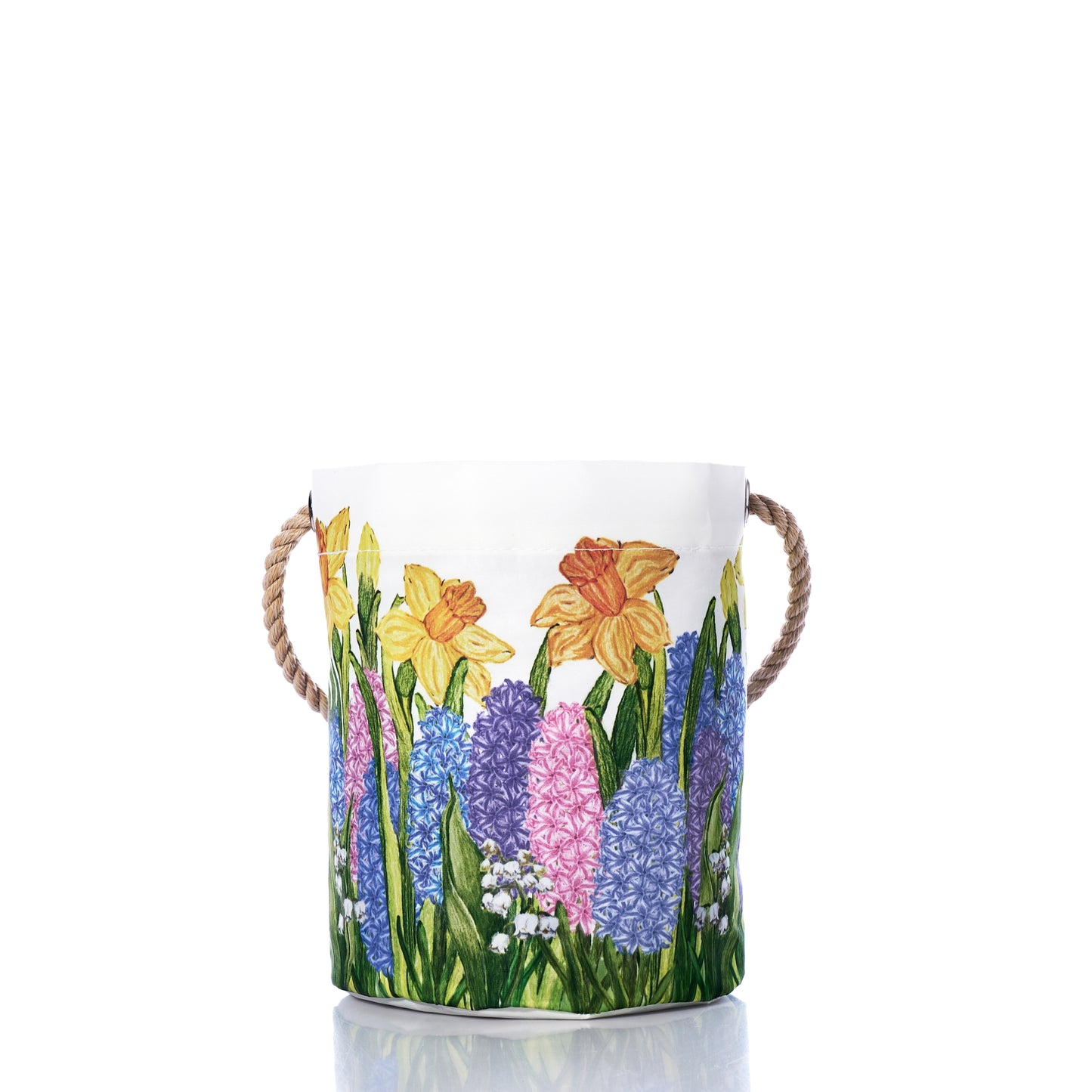 The Multi Floral Bucket Bag by Sea Bags is a canvas storage basket with rope handles, adorned with a colorful floral print of daffodils, hyacinths, and greenery on a white background—a charming and sustainable Easter basket inspired by spring’s vibrant beauty. by Sea Bags