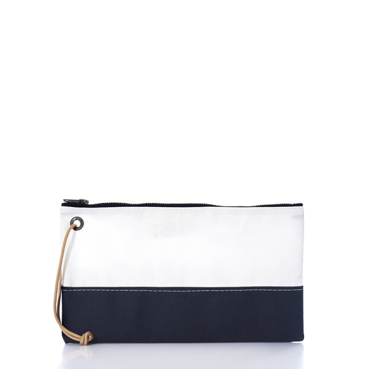 Introducing the Navy Chebeague Large Wristlet by Sea Bags—a rectangular zippered pouch made from reclaimed sailcloth. This stylish accessory showcases a distinctive design with a white upper section, navy blue bottom, visible stitching details, and a tan wrist strap on the left side. Combining sustainability with everyday functionality, this wristlet embodies Sea Bags’ commitment to upcycled materials and timeless style. by Sea Bags