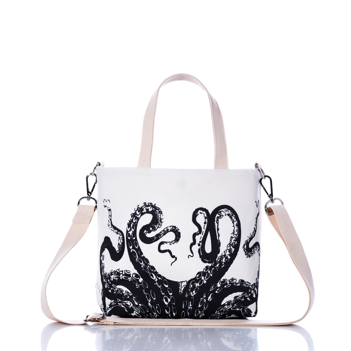 The Octopus Crossbody Tote by Sea Bags is an eco-friendly white bag made from recycled sailcloth, detailed with beige handles and a detachable strap. Showcased against a white background, it features a bold black octopus tentacle design on the front. by Sea Bags