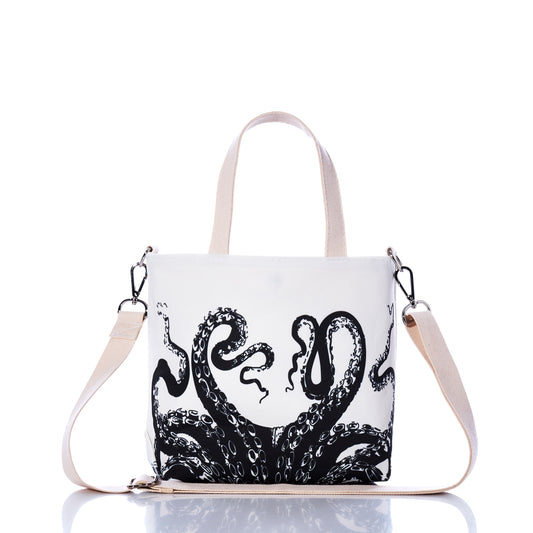 The Octopus Crossbody Tote by Sea Bags is an eco-friendly white bag made from recycled sailcloth, detailed with beige handles and a detachable strap. Showcased against a white background, it features a bold black octopus tentacle design on the front. by Sea Bags