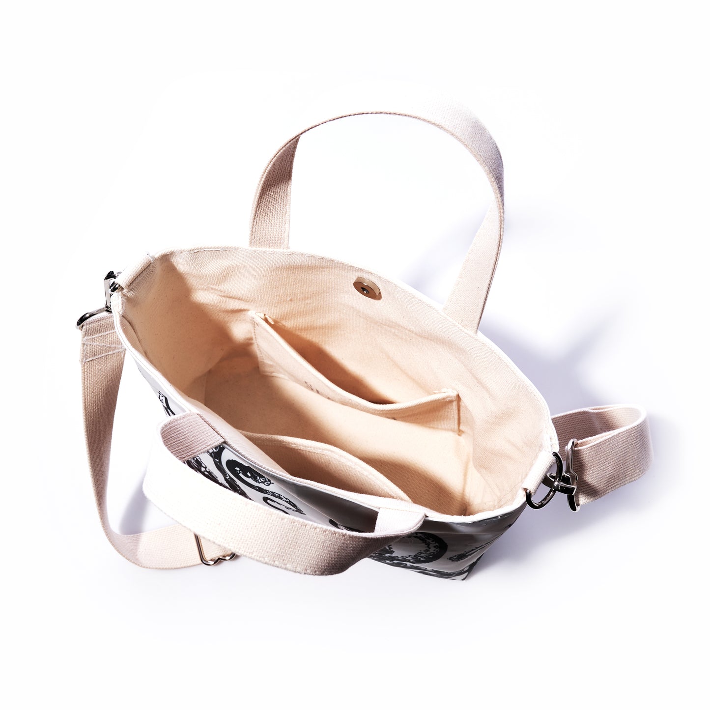 The Octopus Crossbody Tote by Sea Bags features an open canvas design with beige lining, two inner pockets, and beige straps. Shown from above on a white background, this eco-friendly tote is perfect for everyday use. by Sea Bags