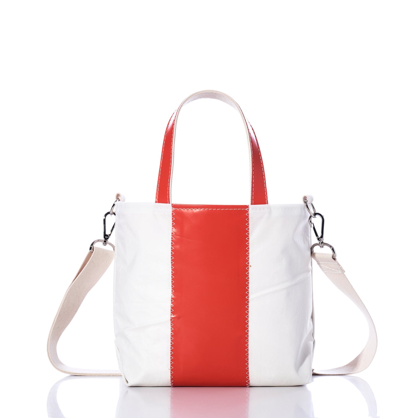 The Trapline Crossbody Tote by Sea Bags is a white recycled sail tote featuring a vertical red stripe, red handles, and a detachable beige shoulder strap—offering a stylish and sustainable bag option, as shown on a white background. by Sea Bags