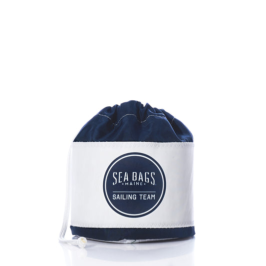 Introducing the Race Day Ditty Bag by Sea Bags—a stylish drawstring sailing bag crafted from recycled sail bags. Featuring a bold Sailing Team logo on the front, this accessory showcases a crisp white base and navy top, beautifully photographed on a clean white background. by Sea Bags