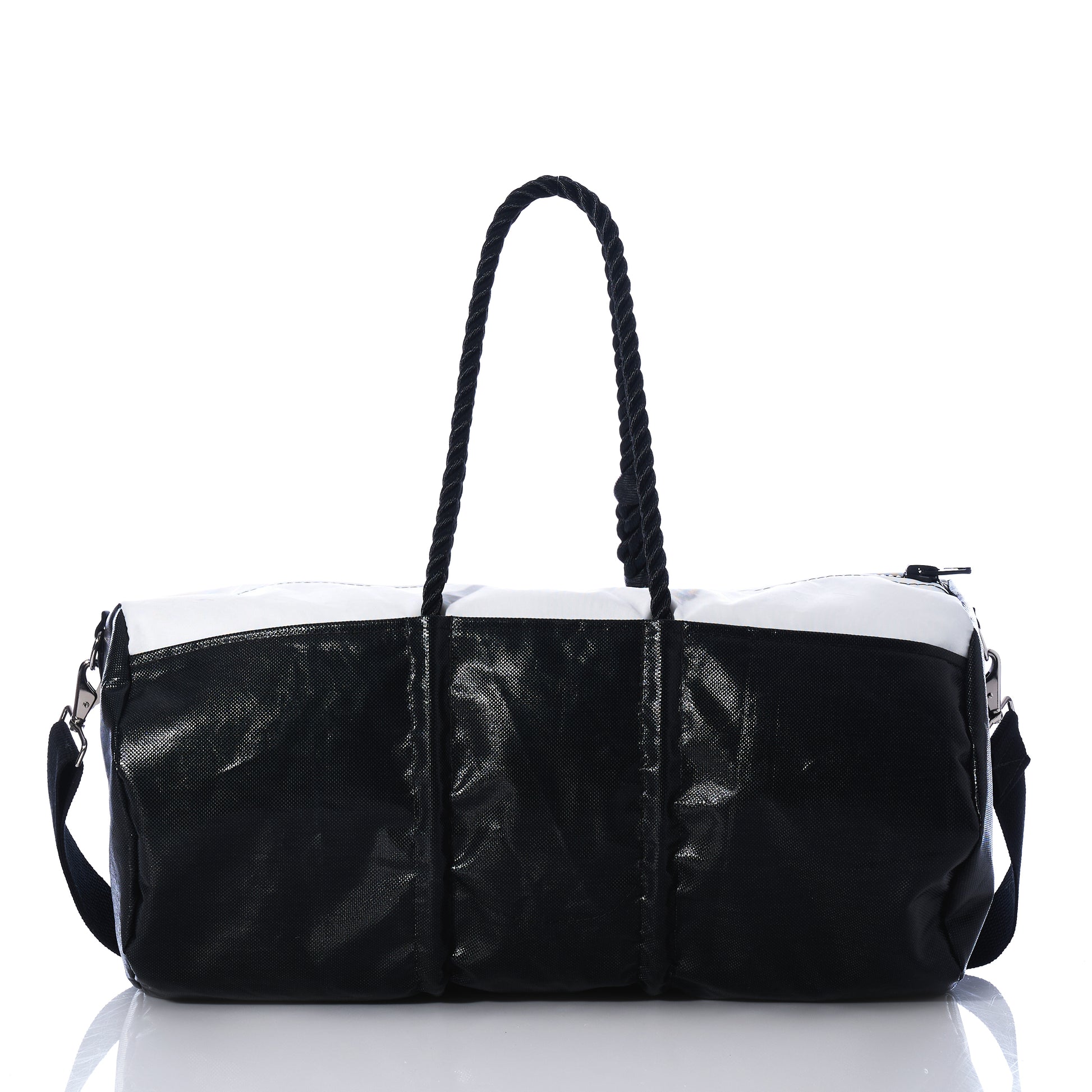 The Sea Bags Black Dragon Duffel, crafted from water-resistant recycled sail cloth, features a striking black-and-white design with two shoulder straps and a zippered top, shown here on a reflective white surface. by Sea Bags
