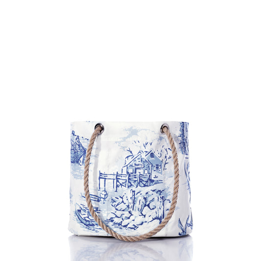 Introducing the Maine Fishing Village Essential Handbag by Sea Bags—a white tote adorned with blue nautical illustrations and thick rope handles, inspired by the scenic coastal beauty of Maine. Expertly crafted from recycled sail cloth, this eco-friendly bag combines classic seaside charm with sustainable style. by Sea Bags