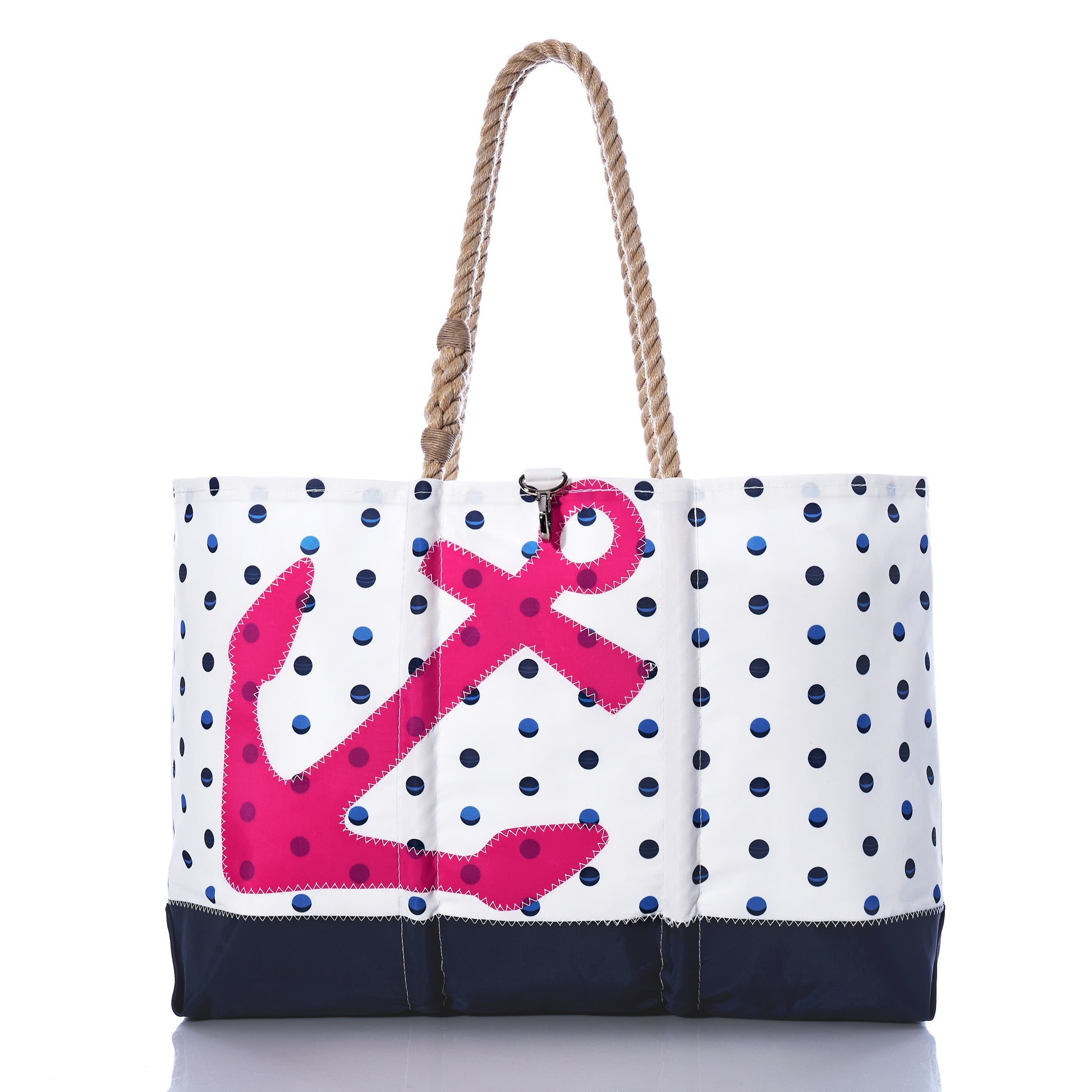 The Sea Bags Fuchsia Anchor  Summer Dots Ogunquit Beach Tote is crafted from recycled sail cloth and features a pattern of blue dots, a bold fuchsia anchor applique, a navy blue base, and sturdy rope handles; shown isolated against a white background. by Sea Bags