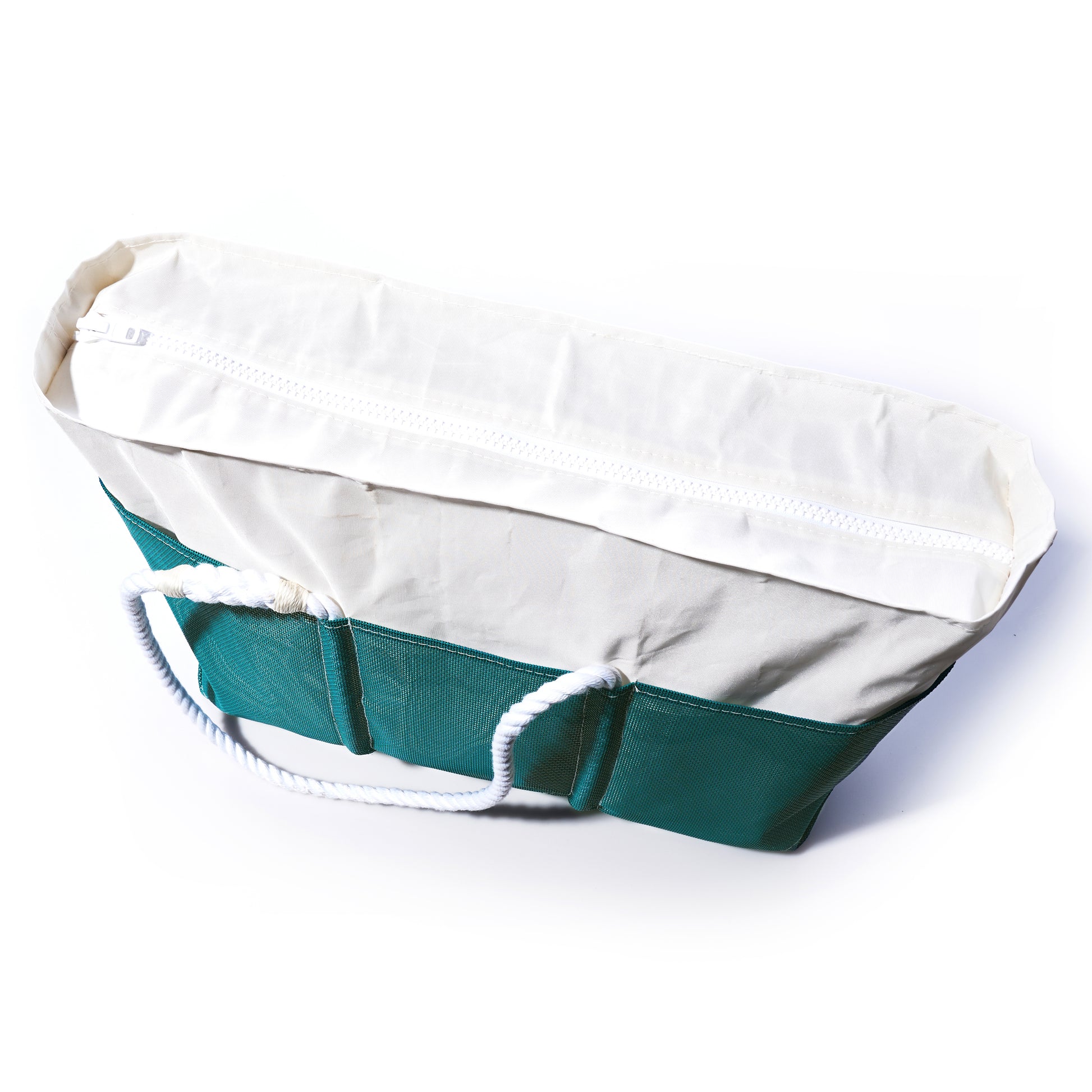 The Ocean Teal Beachcomber Tote by Sea Bags is a white and green canvas beach tote designed in the style of a recycled sail bag, featuring a zippered top and sturdy white rope handles, shown photographed on a white background. by Sea Bags