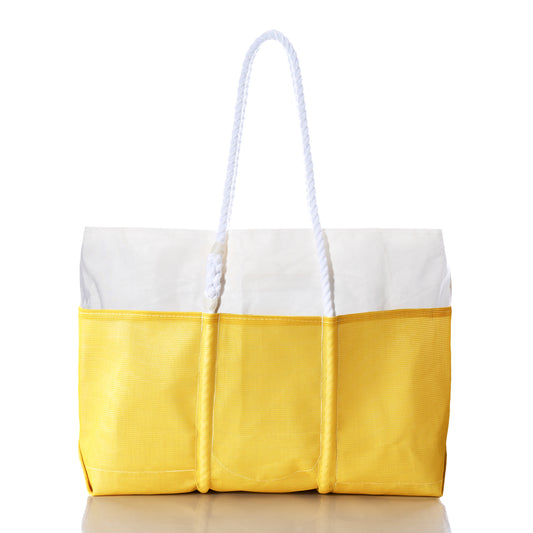 The Sea Bags Goldenrod Beachcomber Tote is a yellow and white recycled sail tote featuring three outer pockets, sturdy rope handles, and a reflective surface underneath, displayed against a plain white background. by Sea Bags