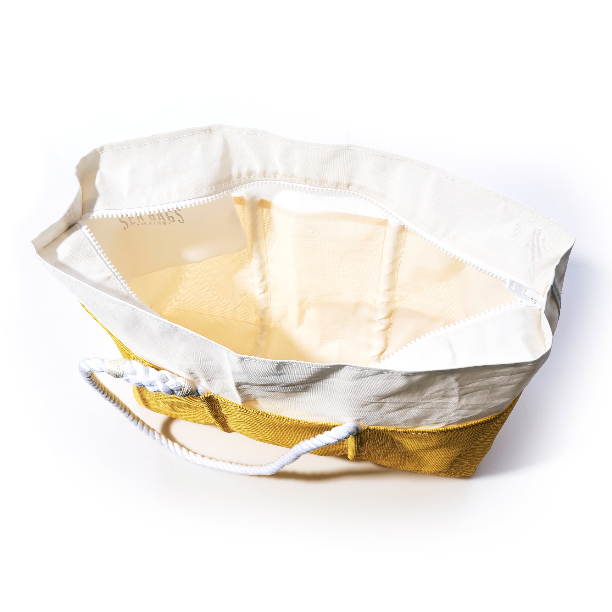 A top-down view of an open Sea Bags Goldenrod Beachcomber Tote, crafted from yellow and white recycled sails with rope handles, displays its spacious empty interior compartments—the perfect beach bag for stylish organization. by Sea Bags