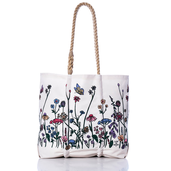 Sea Bags Life is Good Wildflowers Medium Tote, handcrafted in Maine from recycled sail bag materials, features rope handles and a vibrant wildflower and butterfly print along the bottom half, shown on a white background. by Sea Bags