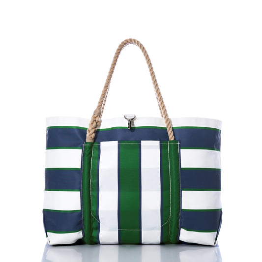 The Sea Bags Preppy Stripe Pier Tote is a spacious bag crafted from recycled sail cloth, showcasing bold navy blue, green, and white vertical and horizontal stripes. Featuring iconic New England rope handles and a metallic clasp, this stylish tote is presented against a clean white background. by Sea Bags