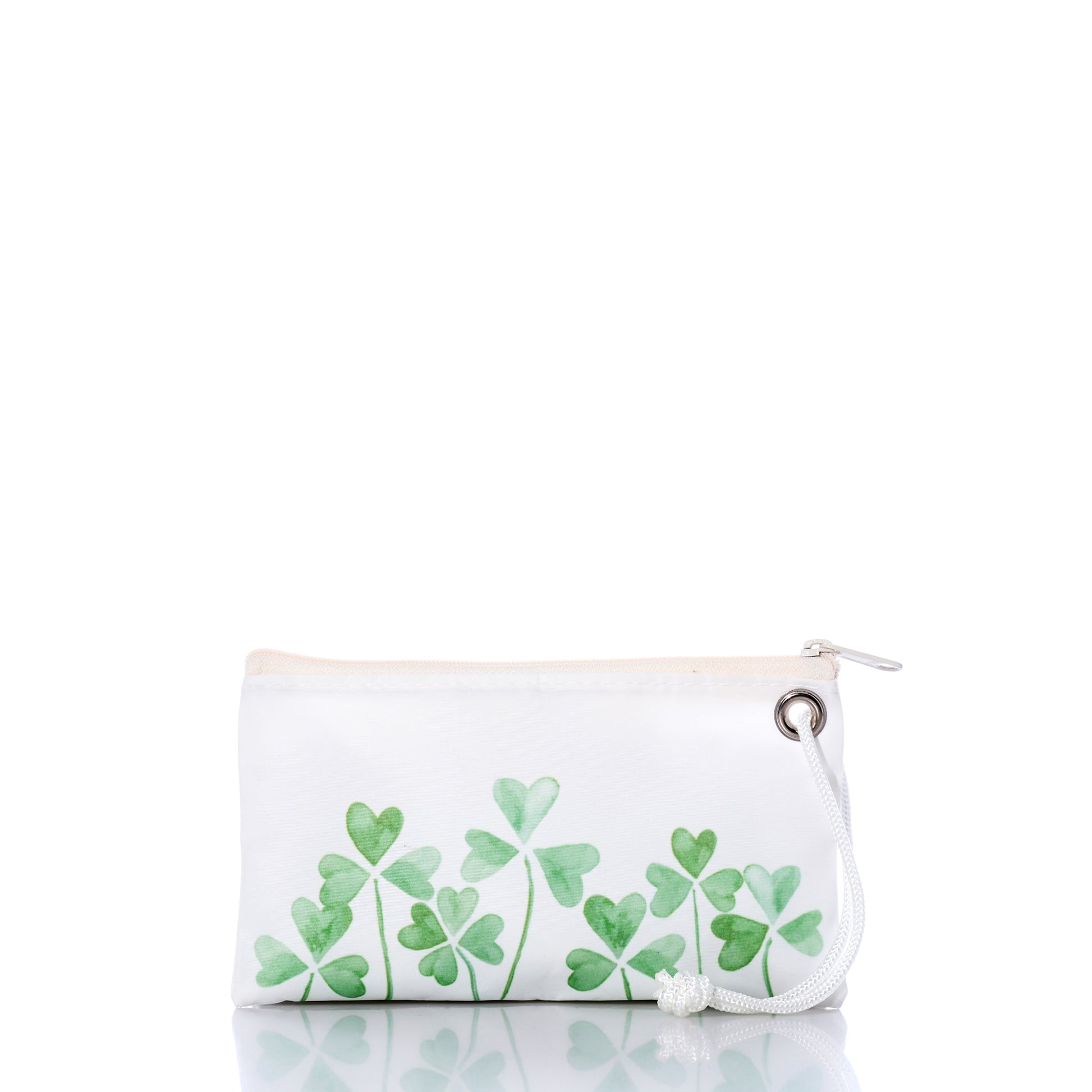 The Sea Bags Field of Clover Wristlet is crafted from recycled sailcloth for eco-friendly style, featuring green four-leaf clover designs, a white zipper, and a white cord loop. It is displayed on a reflective white surface. by Sea Bags