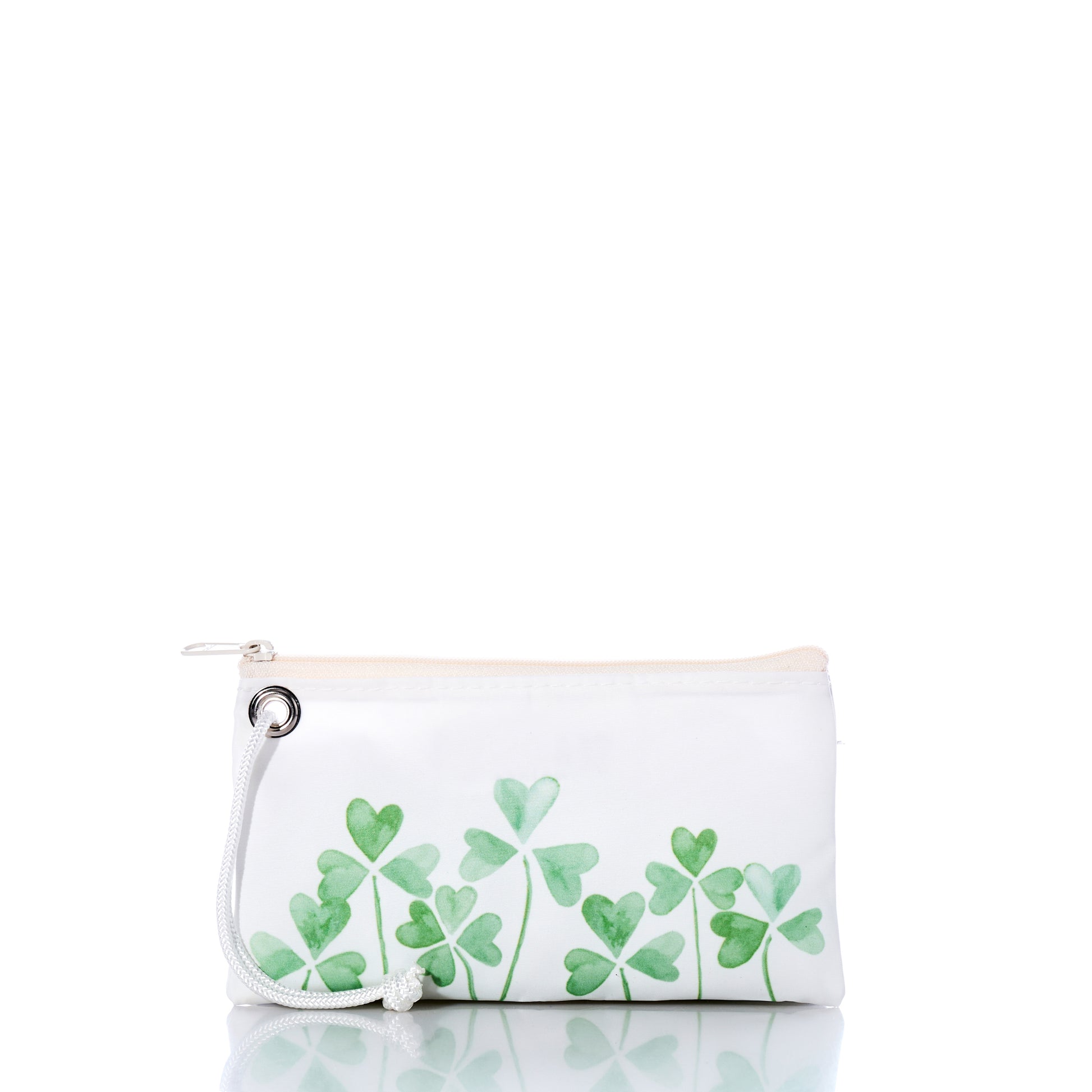 Introducing the Field of Clover Wristlet by Sea Bags—a white zippered pouch featuring a convenient wrist strap and adorned with green watercolor-style clover leaves along the bottom. Expertly crafted from recycled sailcloth for eco-friendly appeal, this sustainable accessory showcases both style and environmental commitment. Displayed against a white background with a subtle reflection, the Field of Clover Wristlet by Sea Bags offers charming design and mindful craftsmanship. by Sea Bags