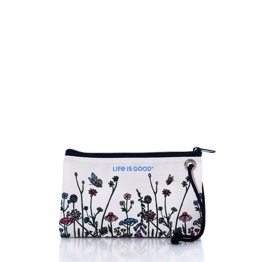 The Sea Bags Life is Good Wildflowers Wristlet features a white zippered pouch with a black strap, beautifully adorned with colorful wildflowers and butterflies. “Life is Good” is printed in blue near the top. Handcrafted in Maine, this stylish accessory blends sustainability with charm. by Sea Bags