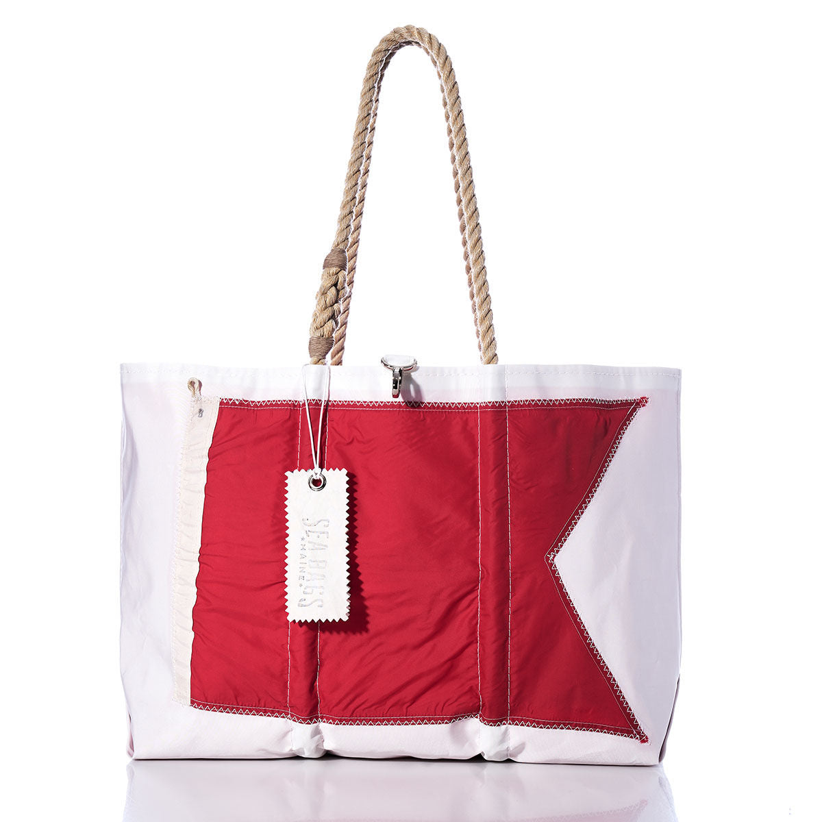 Introducing the Bravo Signal Flag Large Tote by Sea Bags—a large white tote handcrafted from vintage sail cloth, featuring a bold red geometric flag design inspired by maritime signal flags, thick rope handles, and a signature white tag hanging from the handle. by Sea Bags