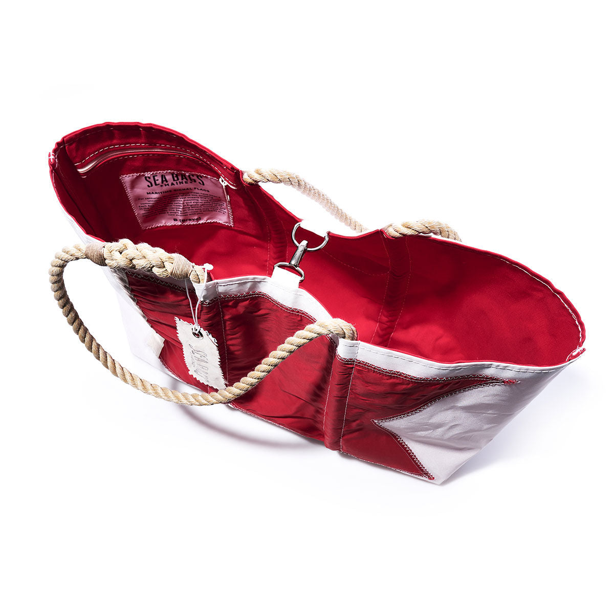 The Bravo Signal Flag Large Tote by Sea Bags is a handcrafted red and silver bag made from vintage sail cloth, featuring rope handles and a red interior. It is shown from above on a white background. by Sea Bags