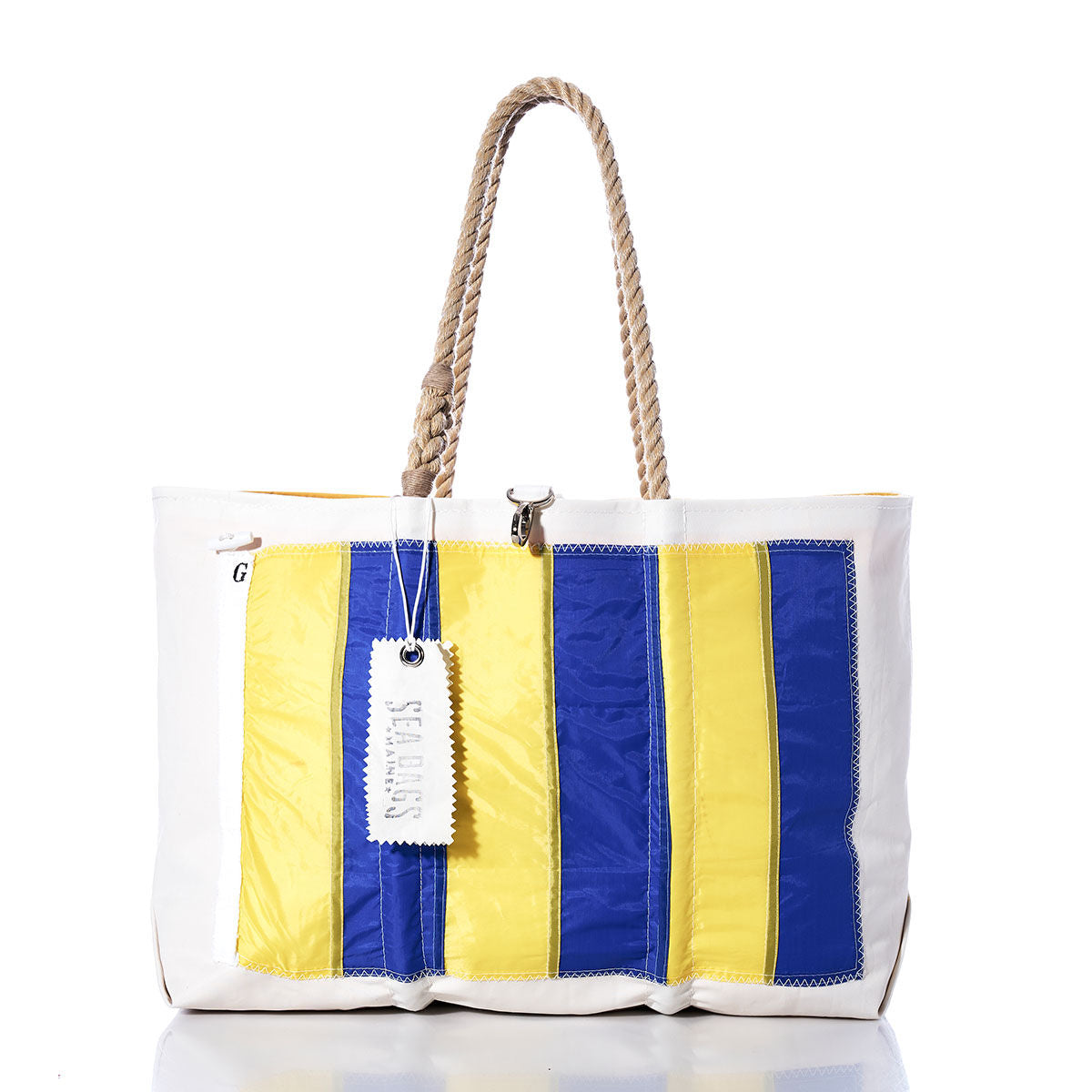 Introducing the Golf Signal Flag Large Tote by Sea Bags—a white tote bag with rope handles, adorned in blue and yellow vertical stripes inspired by vintage maritime signal flags. Expertly crafted from recycled sail cloth, this stylish accessory features a white tag labeled Sea Bags and pays tribute to classic nautical design. by Sea Bags