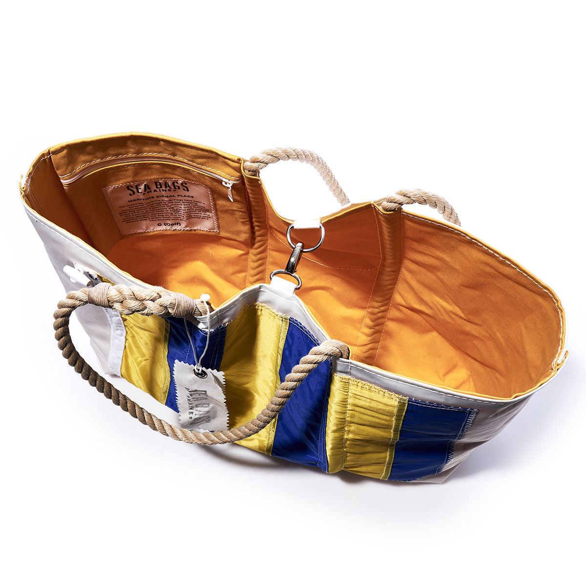 Introducing the Sea Bags Golf Signal Flag Large Tote: crafted from recycled sail cloth, this spacious tote features sturdy rope handles, a cheerful yellow interior, and striking blue, yellow, and white exterior panels inspired by vibrant maritime signal flags. Inside, you’ll find the signature Sea Bags label—a perfect blend of nautical spirit and sustainable style. by Sea Bags