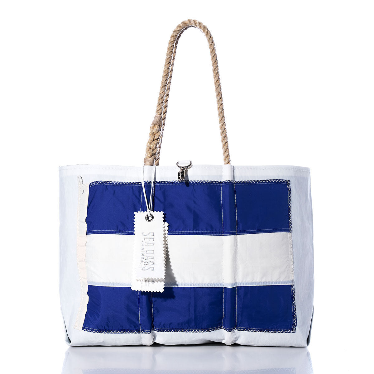 Juliett Signal Flag Large Tote by Sea Bags, handcrafted from vintage sail cloth, features blue and white signal flag patchwork on the front, sturdy rope handles, and a signature white Sea Bags tag. by Sea Bags