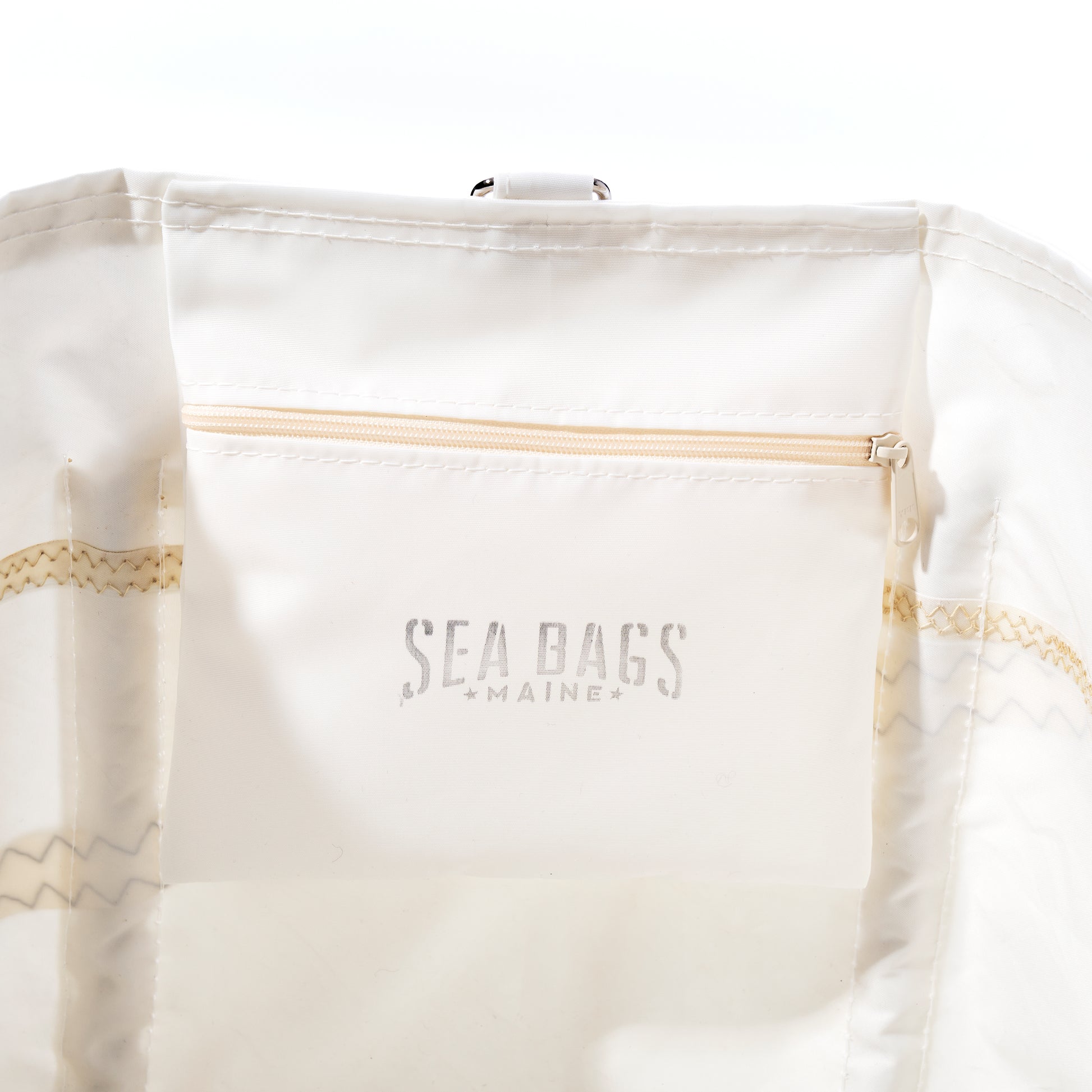 The U.S. Yacht Ensign Wharf Tote by Sea Bags features an interior crafted from recycled sail cloth, a zippered pocket embossed with SEA BAGS MAINE, and visible stitching along the seams, highlighting sustainable craftsmanship and timeless nautical style. by Sea Bags