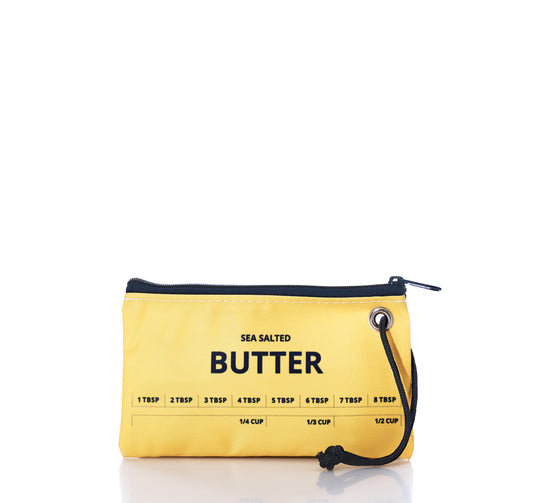 Introducing the Butter Wristlet by Sea Bags—a compact yellow zippered pouch crafted from recycled sail cloth, bringing a hint of coastal charm. Labeled Sea Salted Butter and featuring tablespoon and cup measurements printed on the front, this versatile accessory is perfect for carrying your essentials or even a stick of melted butter wherever you go. by Sea Bags