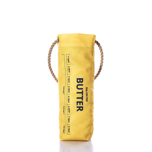 The Butter Wine Bag by Sea Bags, crafted from recycled sail cloth and featuring rope handles, measurement markings, and a SEA SALTED BUTTER label in yellow insulation, stands upright on a white background—an ideal wine bag for your next lobster bake. by Sea Bags