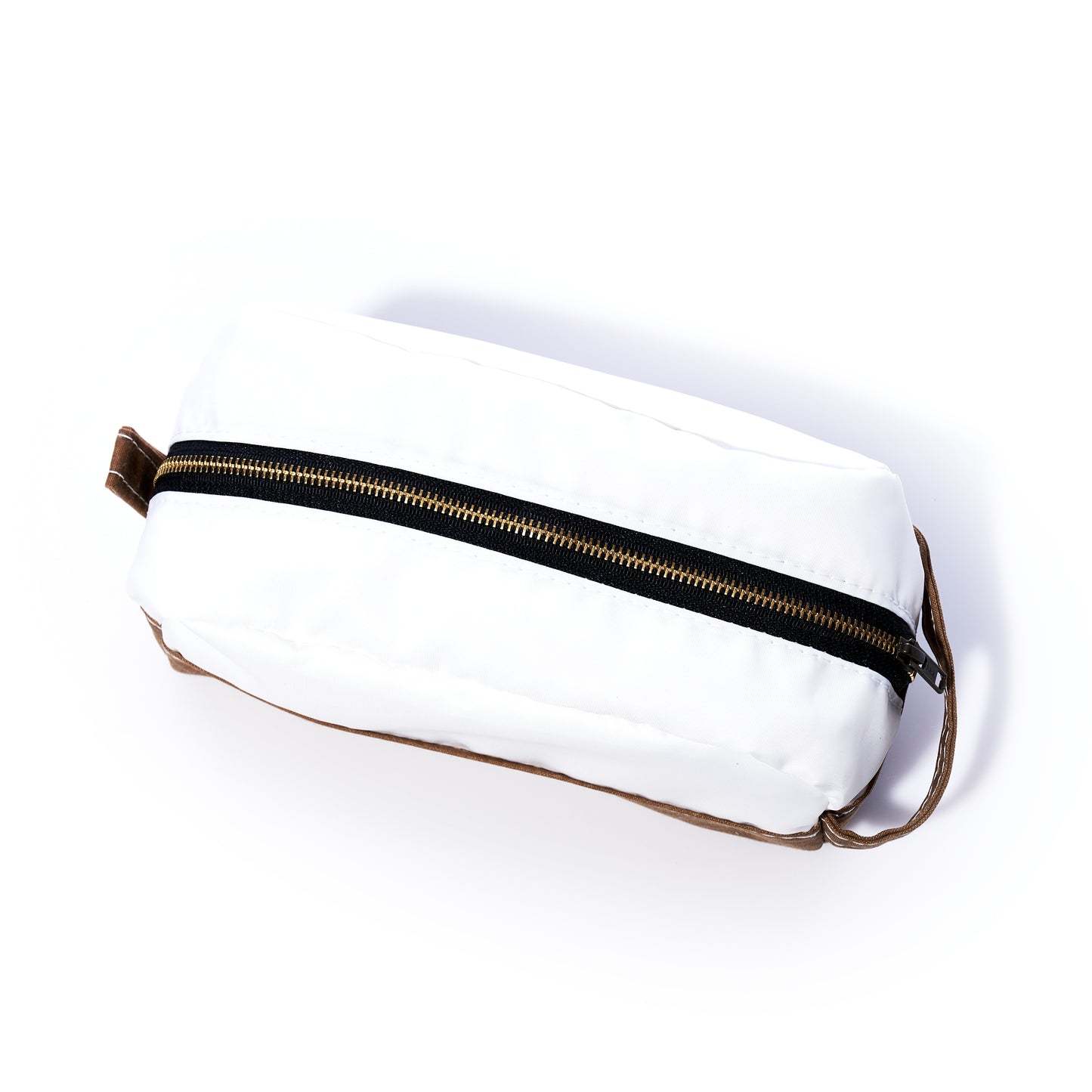 Introducing the Tan Chebeague Toiletry Bag by Sea Bags—a rectangular white zippered pouch crafted from durable Dacron sailcloth with a brown waxed canvas base and handle, photographed on a white background. Perfect for those seeking seaworthy travel bags. by Sea Bags