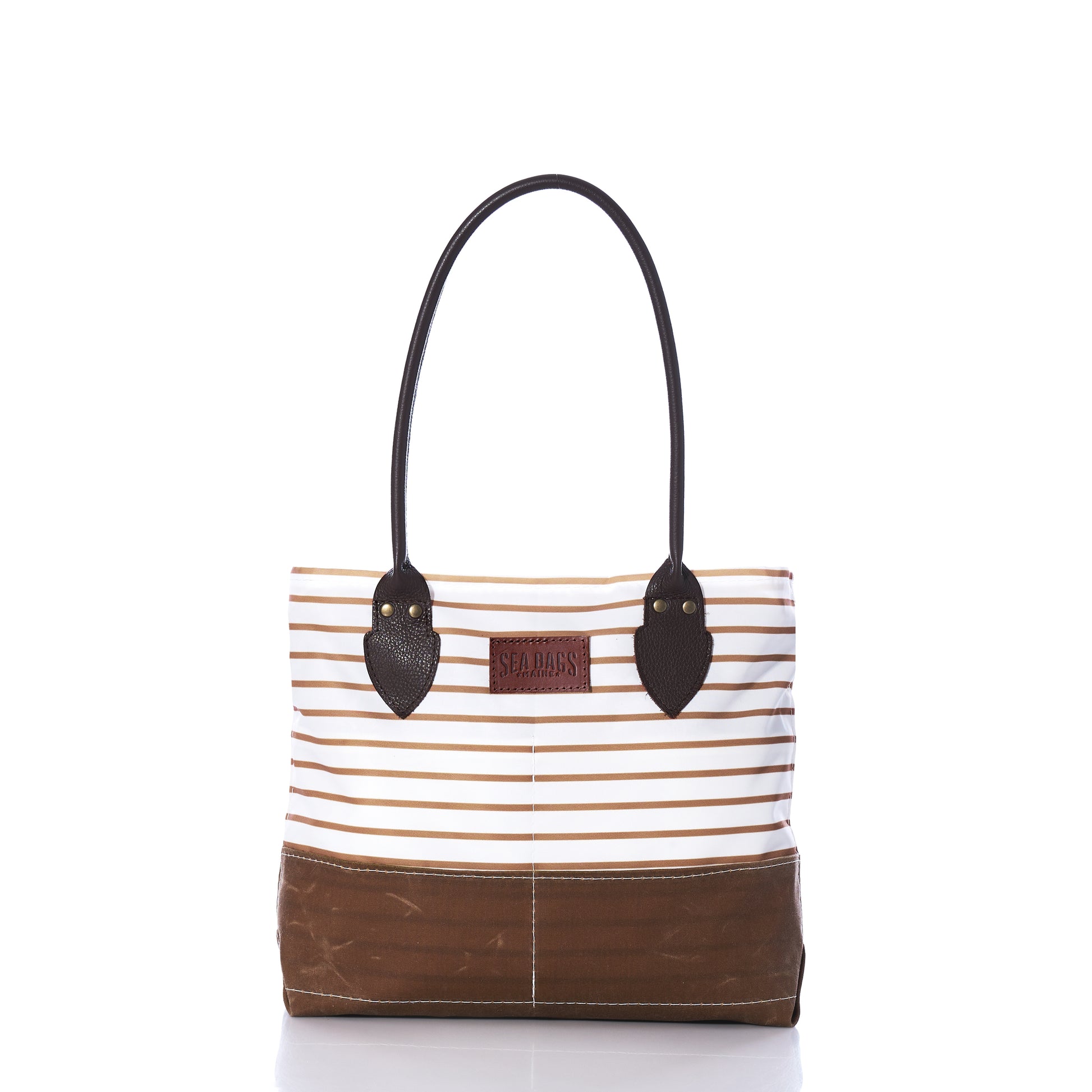 Introducing the Tan Chebeague Stripe Handbag from Sea Bags—a nautical-inspired tote crafted from recycled sail cloth. This stylish bag features a brown base and handles, with horizontal beige and white stripes adorning the upper section. Finished with a small leather patch on the front, it offers a timeless touch of classic charm inspired by Chebeague Island. by Sea Bags
