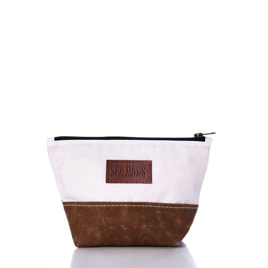 Introducing the Sea Bags Tan Chebeague Cosmetic Bag—a sustainable travel accessory made from recycled sailcloth, featuring a white upper section, tan lower section, zipper closure, and a Sea Bags label on the front. Perfect for carrying your essentials. by Sea Bags