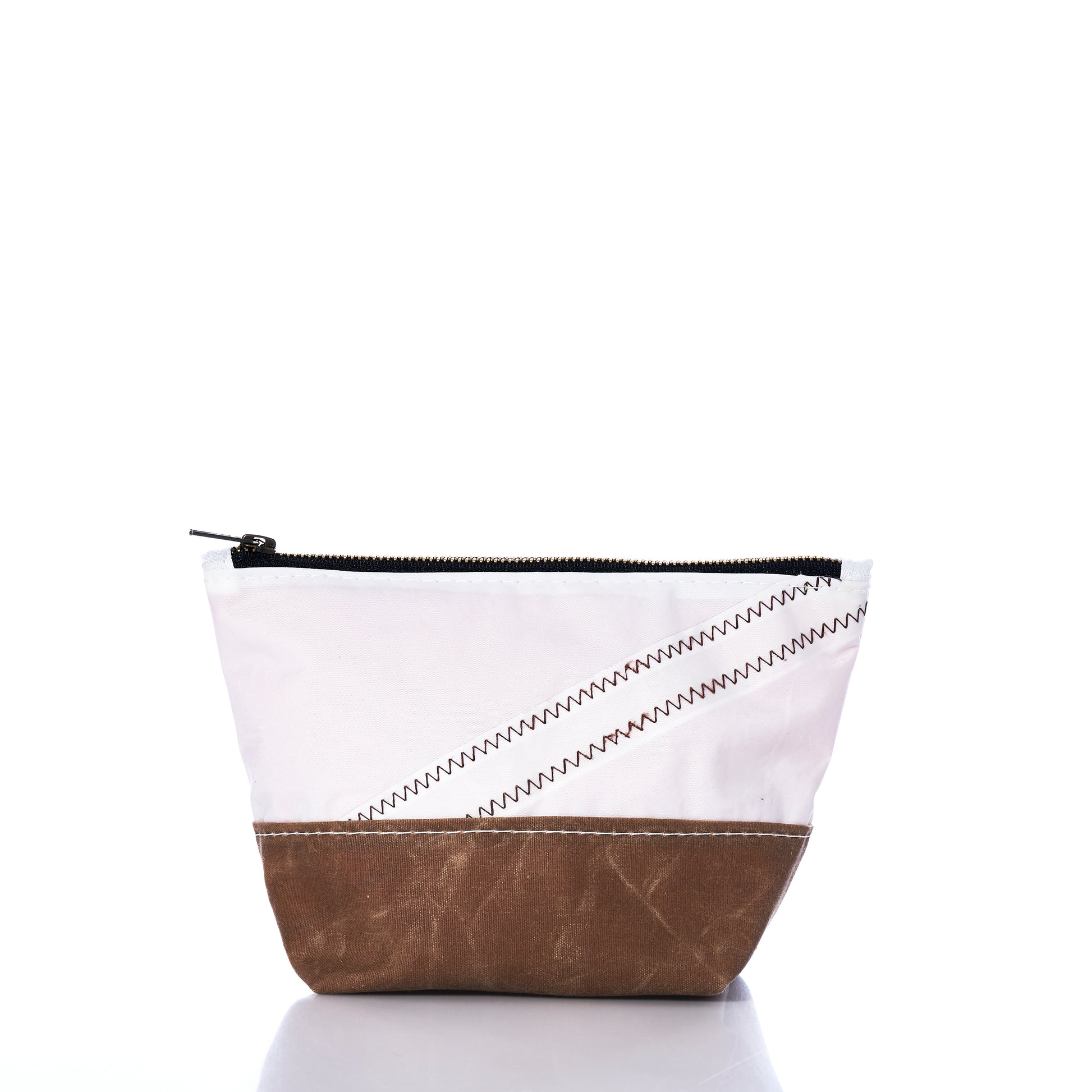 The Tan Chebeague Cosmetic Bag by Sea Bags is a small zippered pouch featuring a white upper section, tan brown bottom, and black zipper. Crafted from recycled sailcloth with decorative zigzag stitching on the white fabric, this versatile cosmetic bag is an ideal travel accessory. by Sea Bags