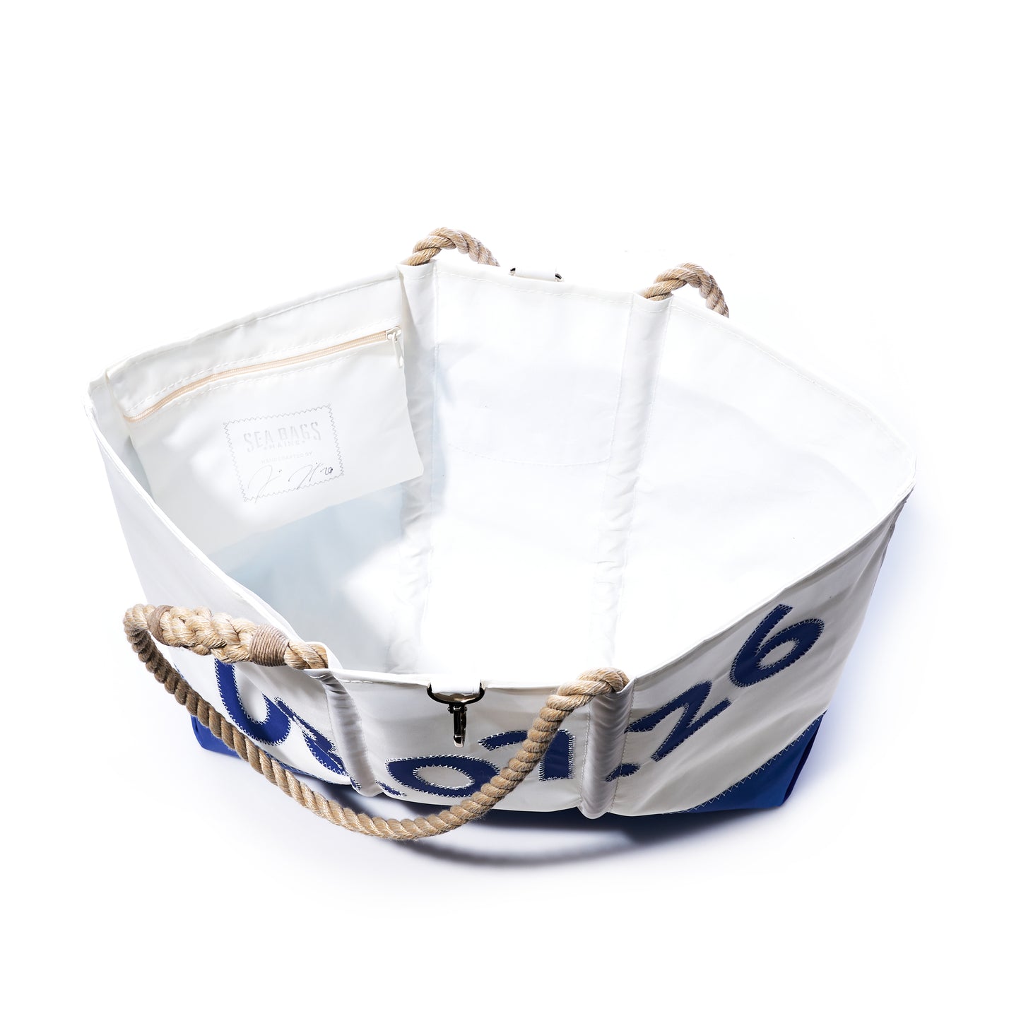 Sea Bags Custom Date Ogunquit Beach Tote in white and blue recycled sailcloth, featuring rope handles, an open interior with a zippered pocket and visible label, photographed on a white background. by Sea Bags