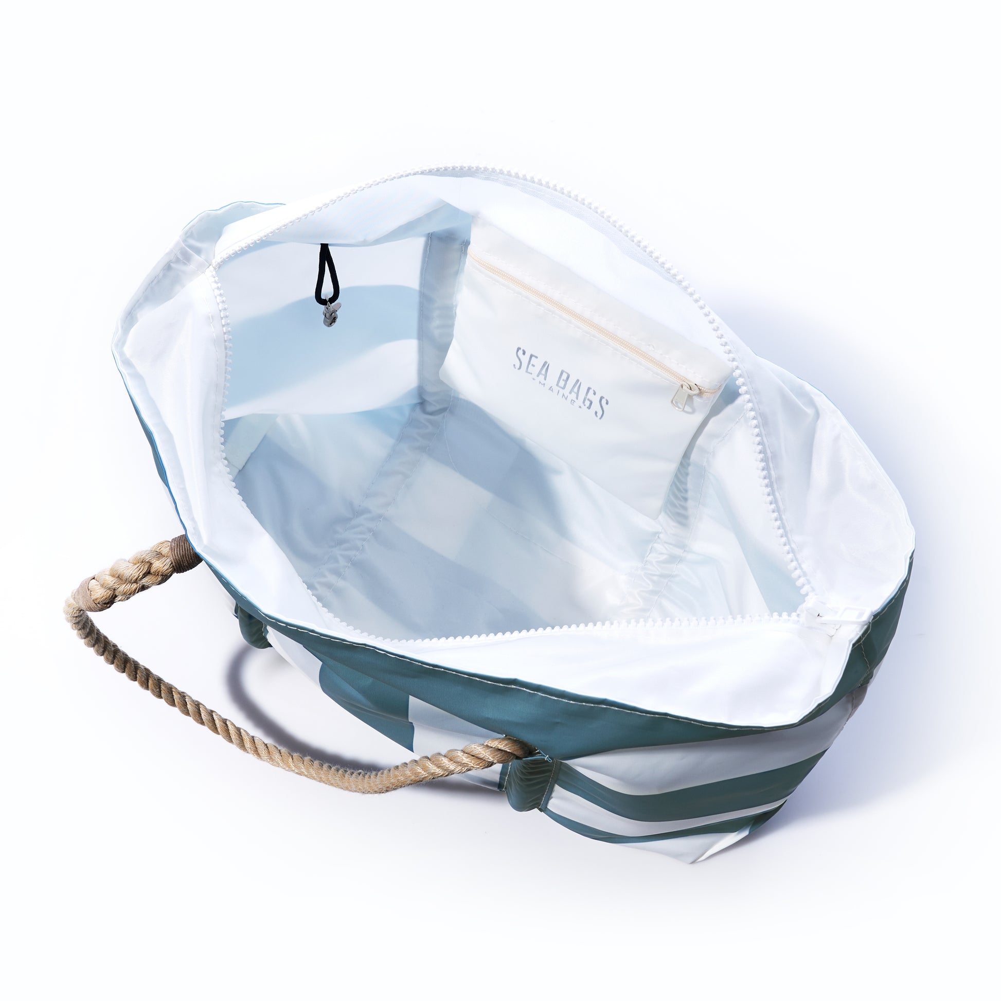 Introducing the Denim Blue Trolley Sleeve Travel Pier Tote from Sea Bags: crafted from open striped recycled sailcloth with sturdy rope handles, a white interior featuring a zippered pocket labeled SEA BASS, and a black hook attached inside—perfect for travel with its convenient trolley sleeve that makes airport transit effortless. by Sea Bags