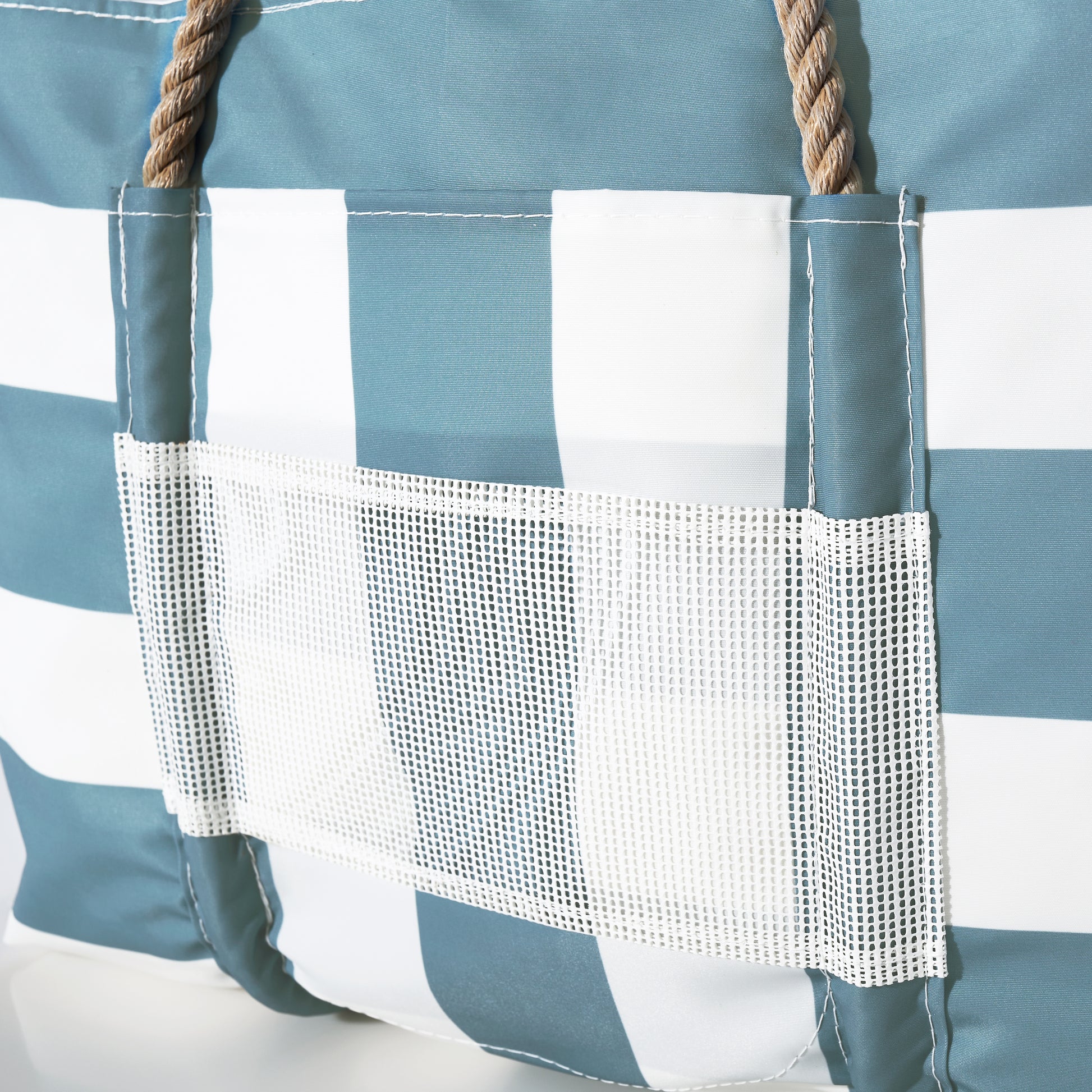 Close-up of the Sea Bags Denim Blue Trolley Sleeve Travel Pier Tote, featuring a blue and white checkered design, sturdy rope handles, a white mesh front pocket, and made from durable recycled sailcloth. by Sea Bags