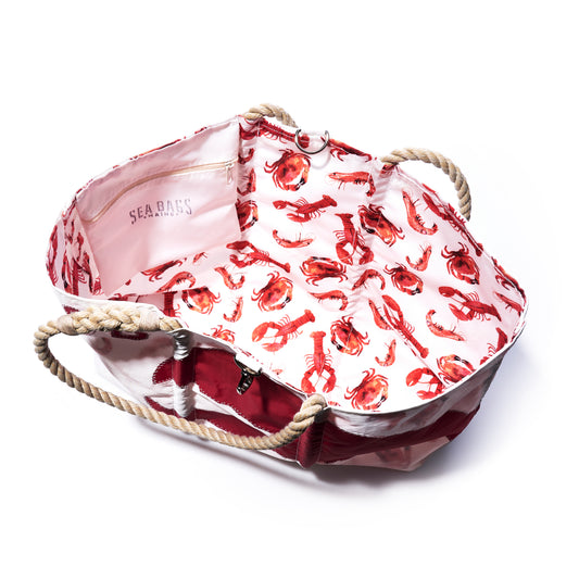 Introducing the Custom Monogram Red Lobster Claw Large Tote by Sea Bags—a striking open tote bag crafted from recycled sailcloth. This coastal-inspired bag features sturdy rope handles, a bold red base, and a white interior lining adorned with a vibrant red lobster claw pattern. The spacious interior includes a convenient pocket with the Sea Bags brand name. Ideal as a personalized gift for any coastal enthusiast.
