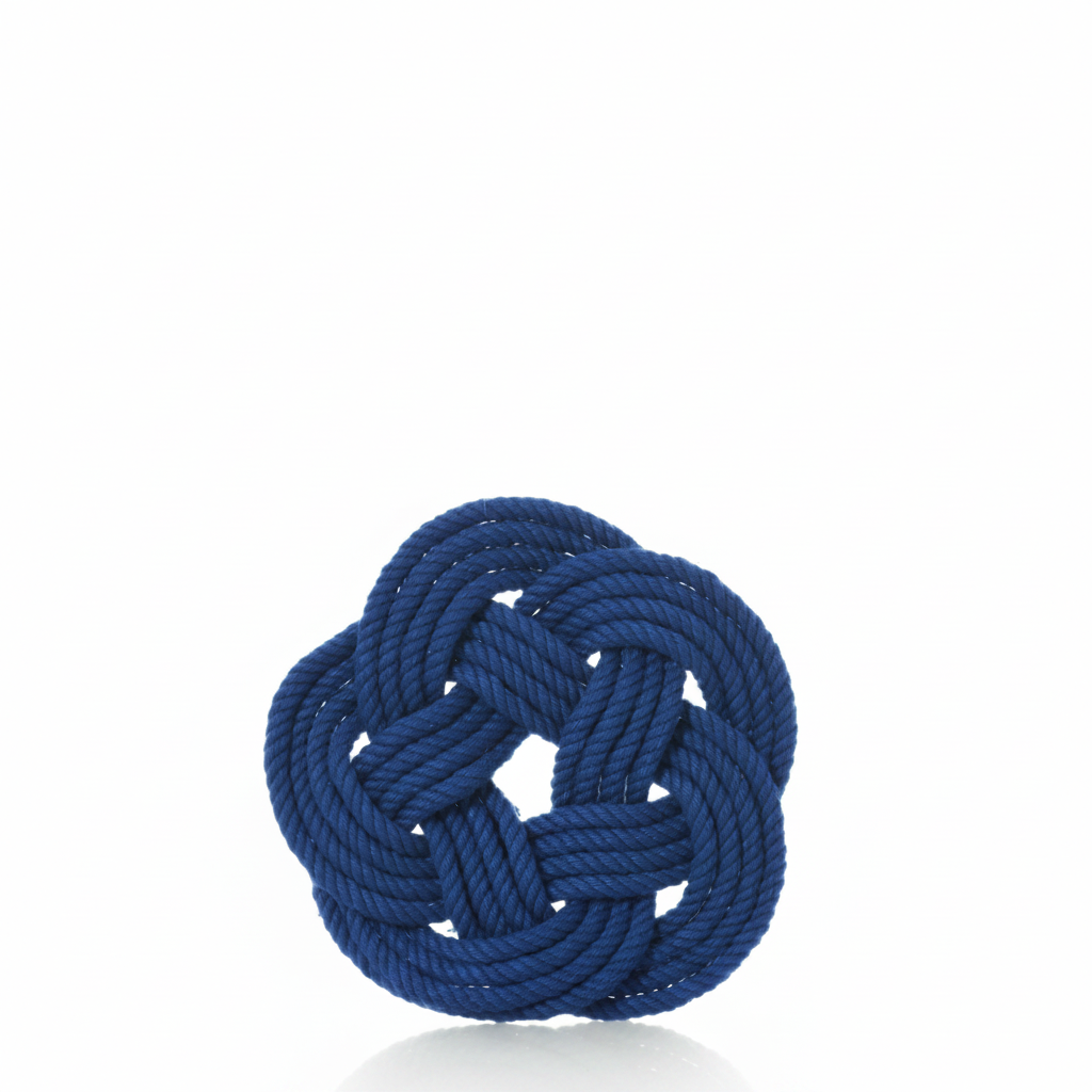 A set of four Nautical Sailor Knot Coasters Cobalt by true is displayed against a plain white background, each featuring a neatly tied blue Turk’s head knot in a round, intricate pattern with a subtle reflection below.
